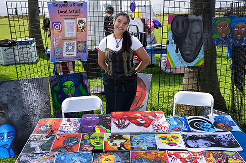a girl tending a booth at the artful minds event